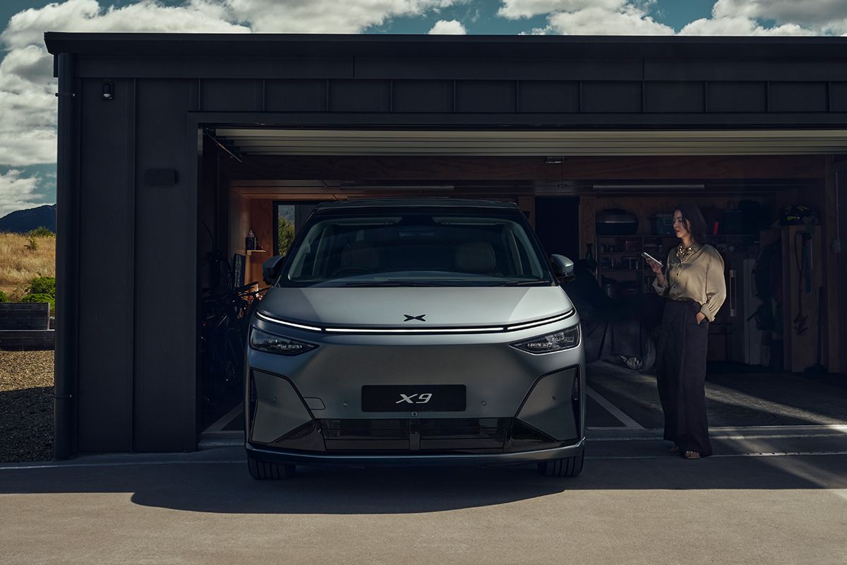 Front des neuen XPENG X9 - Fahrzeug frontal von vorne Heck steht noch in einer Garage, Front ist draußen