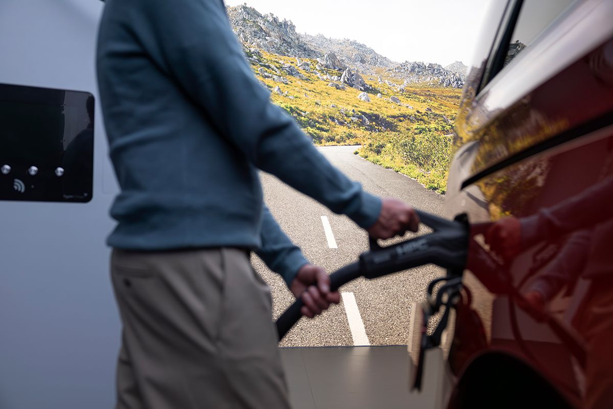 Der neue VLE wird von einem Mann an die Ladestation gehangen.