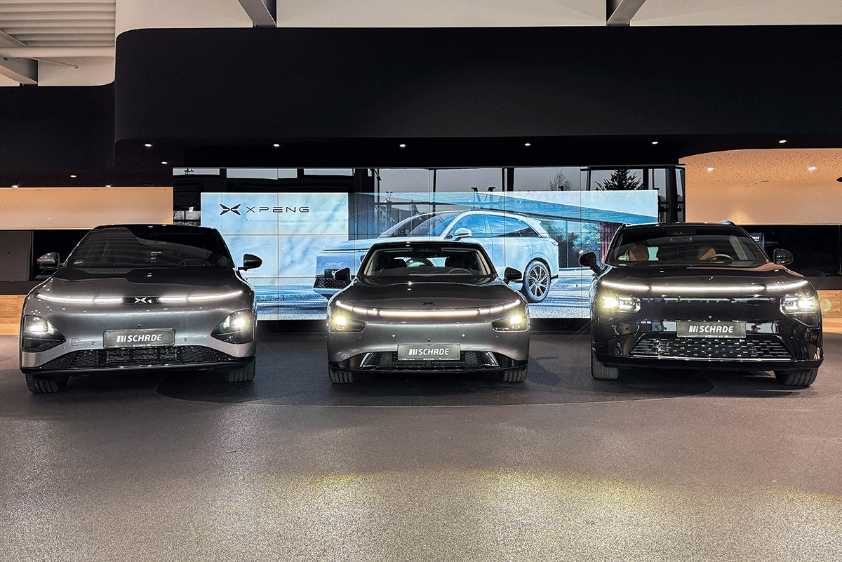 3 Autos der Marke XPENG stehen vor einer digitalen Wand