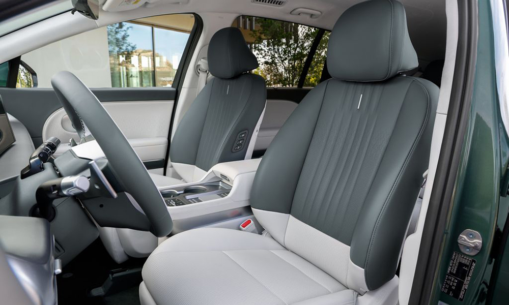 Hyundai IONIQ 9. Durch die Fahrertür sind die Vordersitze in Hellgrau und Dunkelgrau fotografiert.
